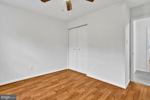 unfurnished bedroom with ceiling fan, light hardwood / wood-style floors, and a closet