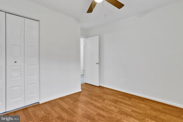 unfurnished bedroom featuring ceiling fan, light hardwood / wood-style floors, and a closet