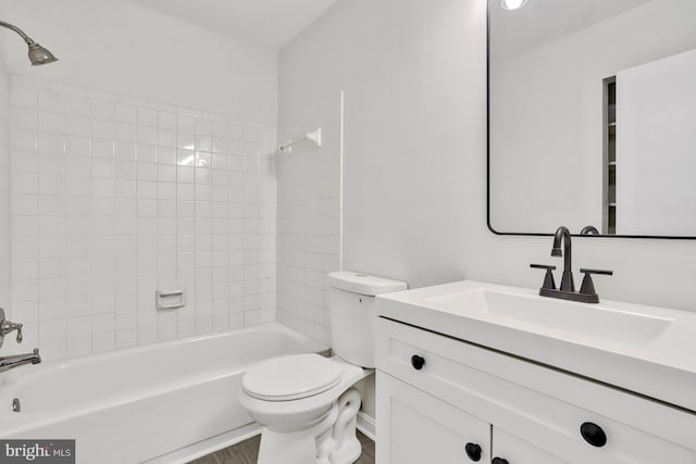 full bathroom featuring vanity, toilet, tiled shower / bath combo, and wood-type flooring