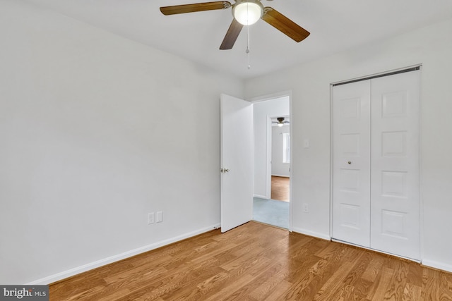 unfurnished bedroom with ceiling fan, light hardwood / wood-style floors, and a closet