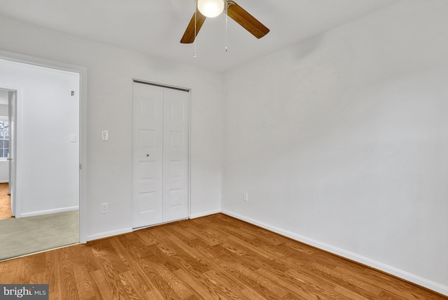 unfurnished bedroom with ceiling fan, a closet, and light wood-type flooring