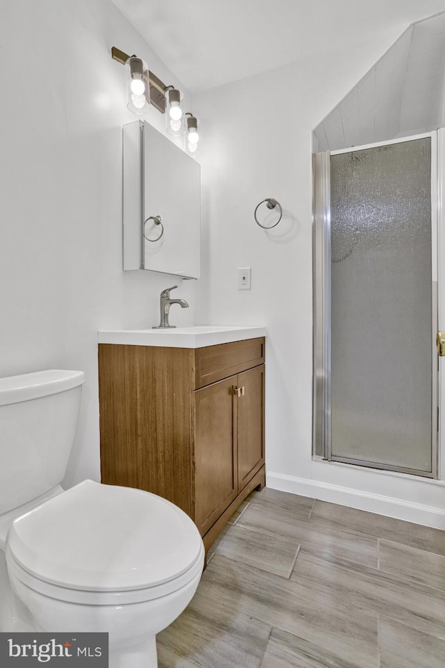 bathroom featuring vanity, walk in shower, and toilet