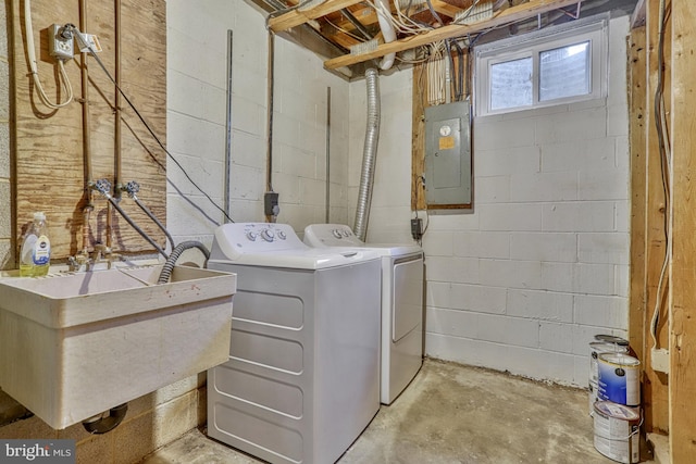 clothes washing area with electric panel, sink, and washer and dryer