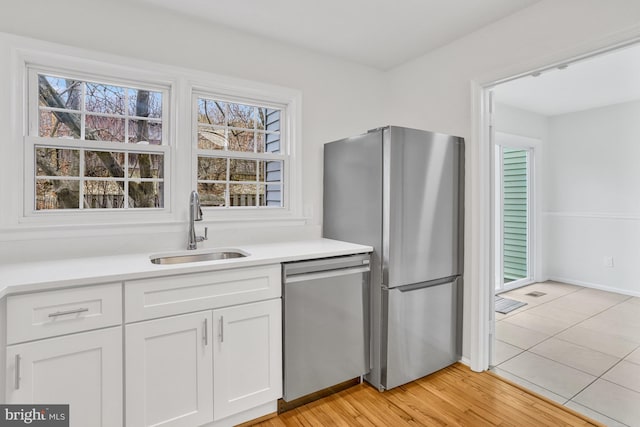 kitchen with white cabinetry, appliances with stainless steel finishes, sink, and plenty of natural light