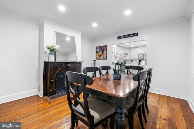 dining area with crown molding and light wood-type flooring