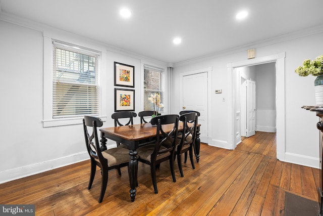 dining room with ornamental molding and dark hardwood / wood-style flooring