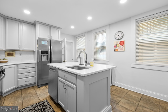 kitchen with gray cabinets, an island with sink, appliances with stainless steel finishes, and sink