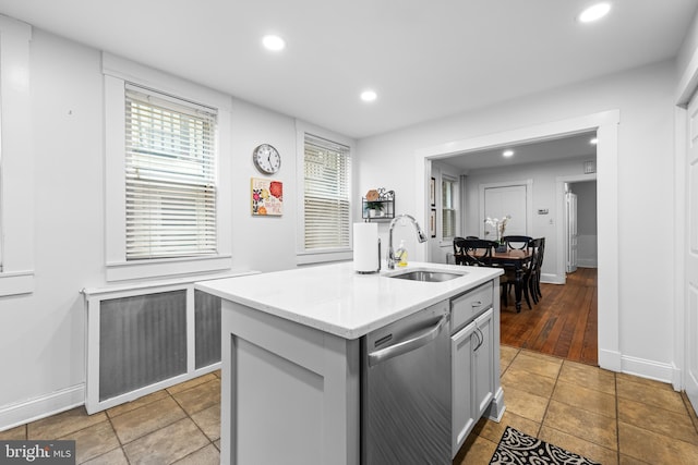 kitchen featuring gray cabinetry, sink, dishwasher, and a center island with sink