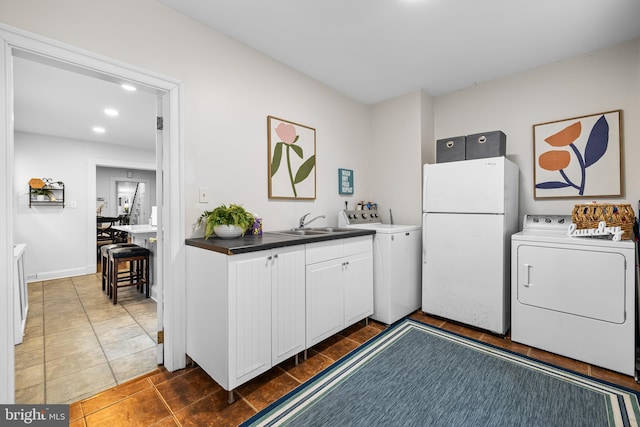 kitchen with white cabinetry, sink, dark tile patterned floors, and white refrigerator