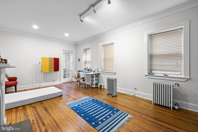 interior space featuring crown molding, radiator heating unit, and wood-type flooring