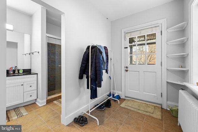 interior space featuring sink, radiator heating unit, and light tile patterned floors