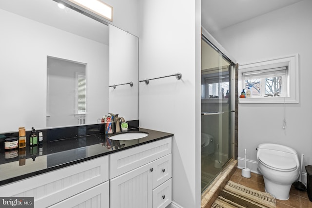 bathroom with vanity, toilet, tile patterned floors, and a shower with shower door