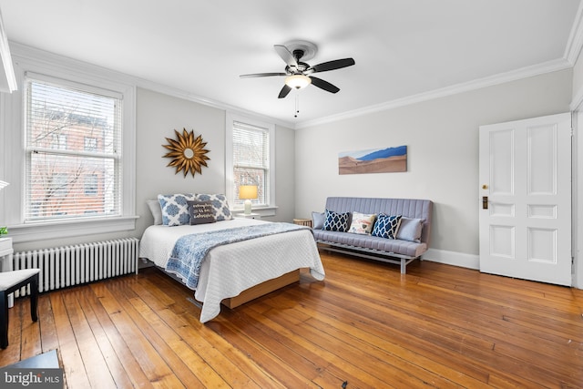 bedroom with radiator, wood-type flooring, ornamental molding, and ceiling fan