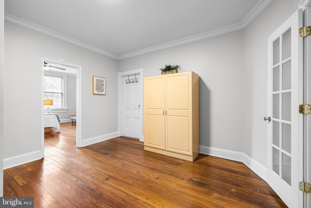 unfurnished bedroom featuring ornamental molding and dark wood-type flooring