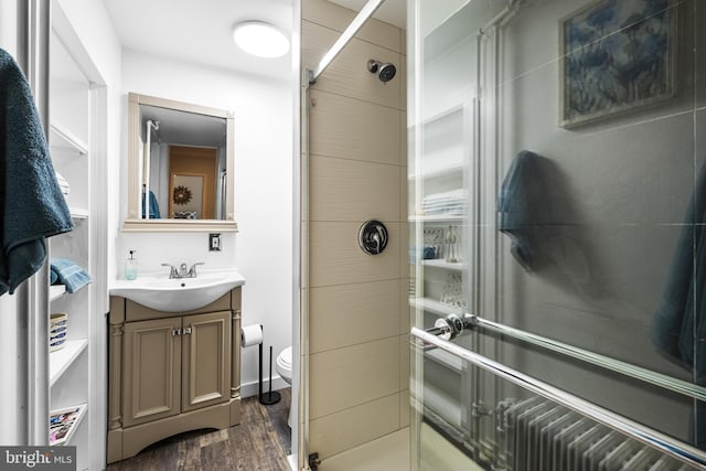 bathroom featuring vanity, a shower, wood-type flooring, and toilet