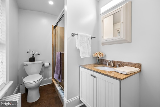 bathroom with vanity, toilet, tile patterned flooring, and a shower with door