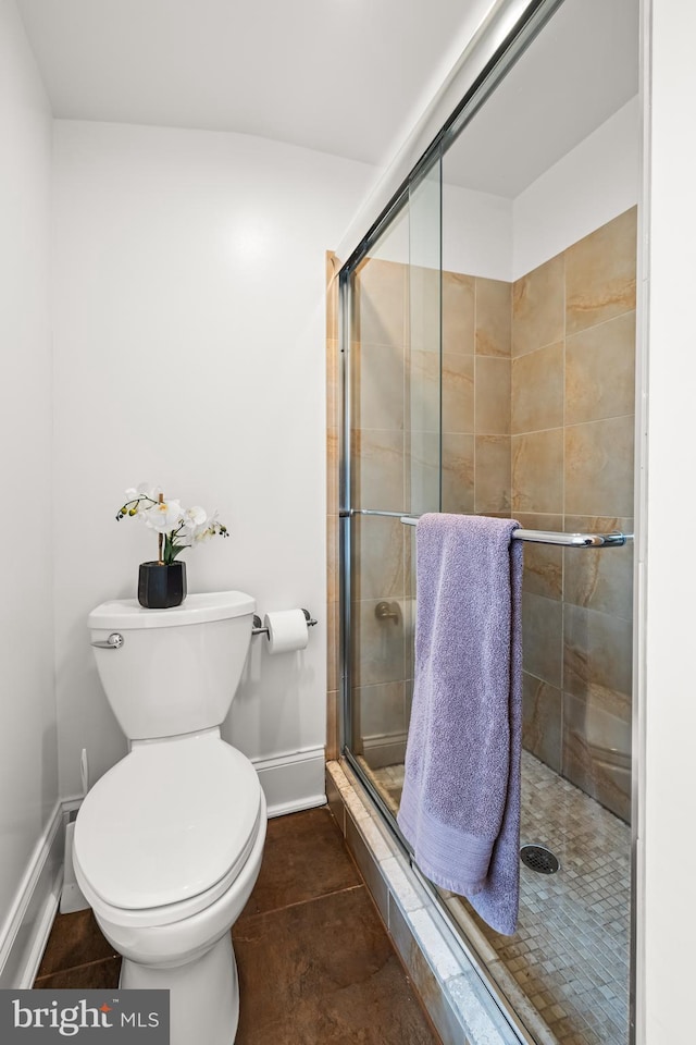 bathroom with tile patterned floors, toilet, and an enclosed shower