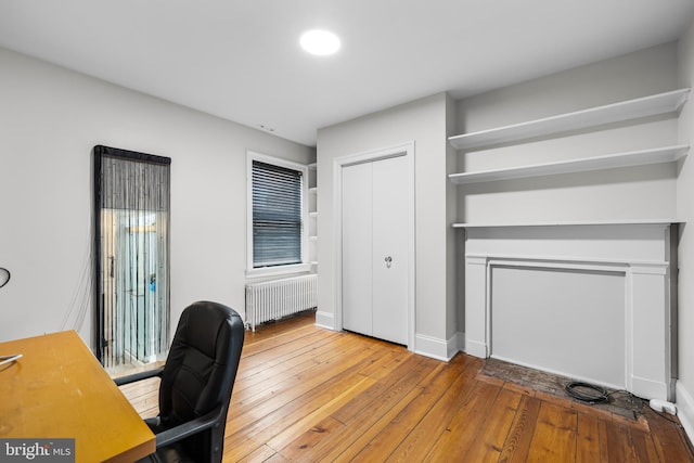 home office with wood-type flooring and radiator