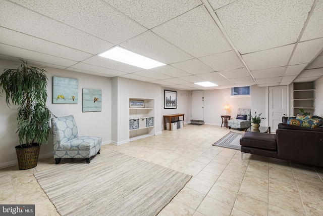 living room featuring a drop ceiling and tile patterned floors