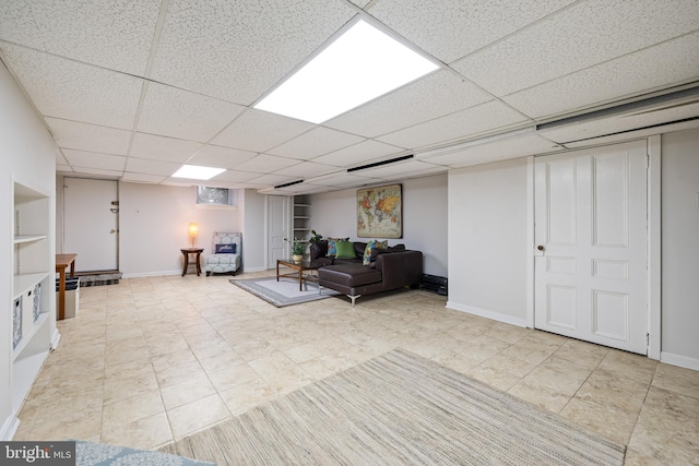 unfurnished living room featuring a drop ceiling