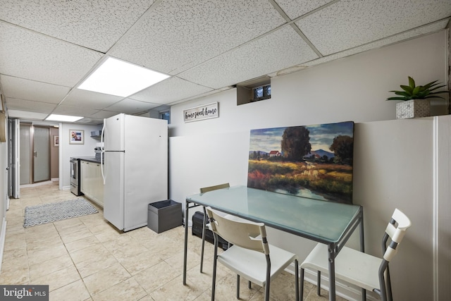 tiled dining space featuring a paneled ceiling