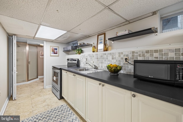 kitchen with sink, a drop ceiling, stainless steel range with electric cooktop, and backsplash