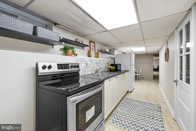 kitchen featuring electric stove, sink, a paneled ceiling, white cabinetry, and white fridge