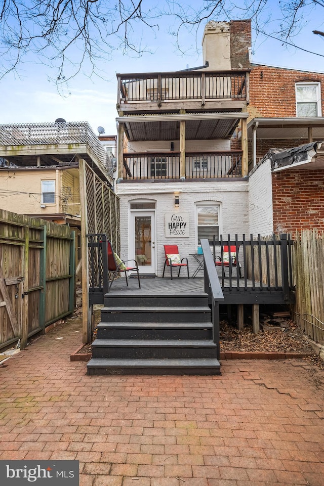 back of house featuring a balcony and a deck