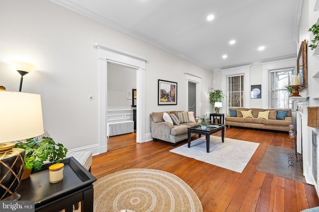 living room with hardwood / wood-style flooring, crown molding, and radiator heating unit