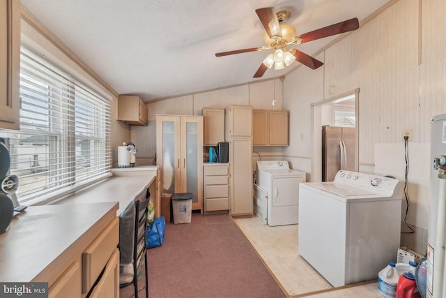 laundry area featuring ceiling fan, cabinets, separate washer and dryer, and wood walls