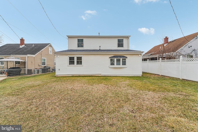 rear view of property featuring a lawn