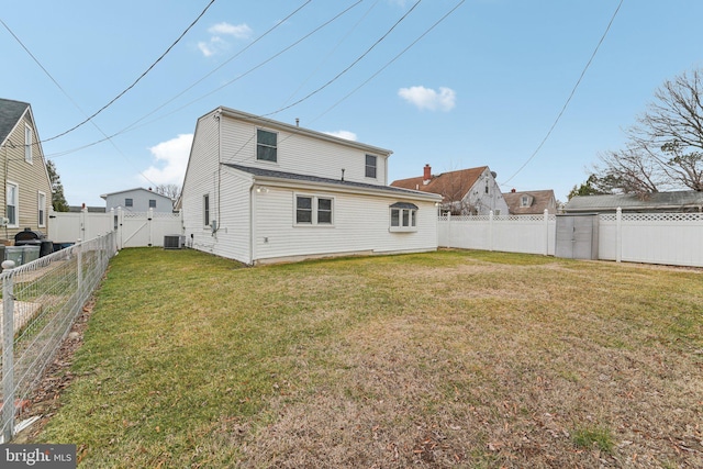 back of property featuring a yard and central AC