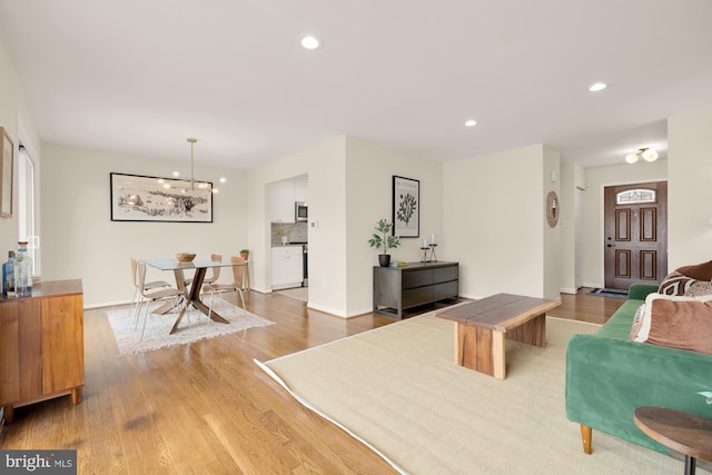 living room with a notable chandelier and light wood-type flooring