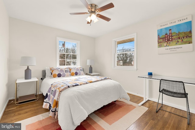 bedroom featuring ceiling fan, wood-type flooring, and multiple windows