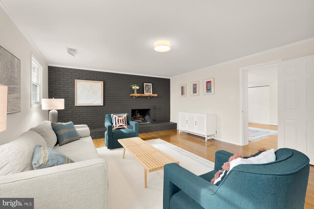 living room with hardwood / wood-style floors, a fireplace, and ornamental molding