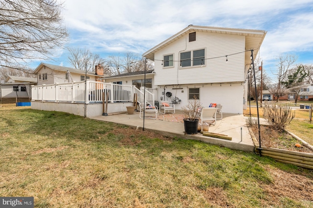 back of house featuring a patio, a deck, and a lawn