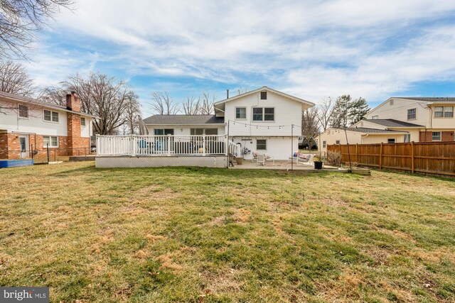 back of property featuring a yard, a deck, and a patio area