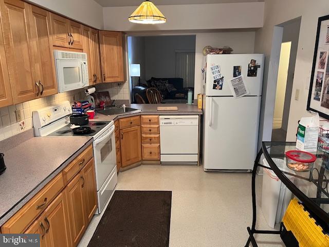 kitchen with tasteful backsplash, white appliances, and pendant lighting