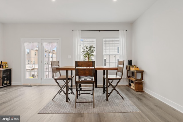 dining space featuring wine cooler and light hardwood / wood-style floors