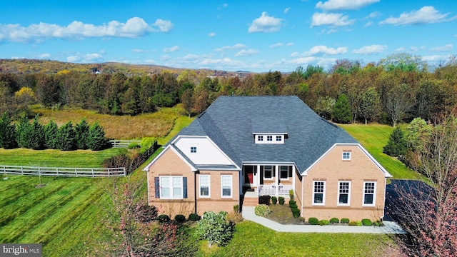 view of front of house featuring a front lawn and a rural view