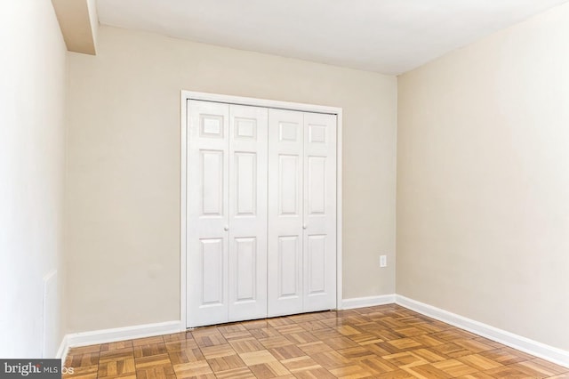 unfurnished bedroom with light parquet flooring and a closet