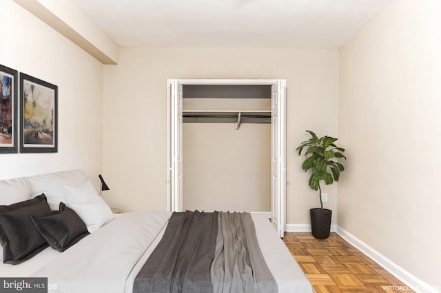 bedroom featuring parquet floors and a closet