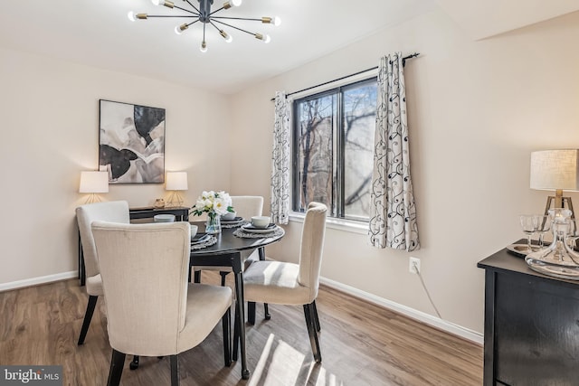 dining area with hardwood / wood-style floors and a notable chandelier