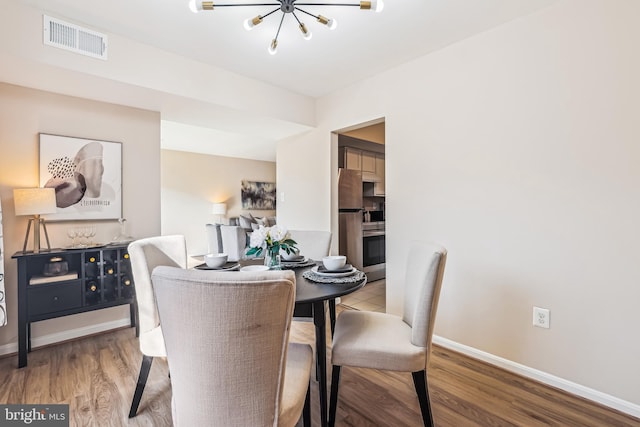 dining space featuring a notable chandelier and wood-type flooring