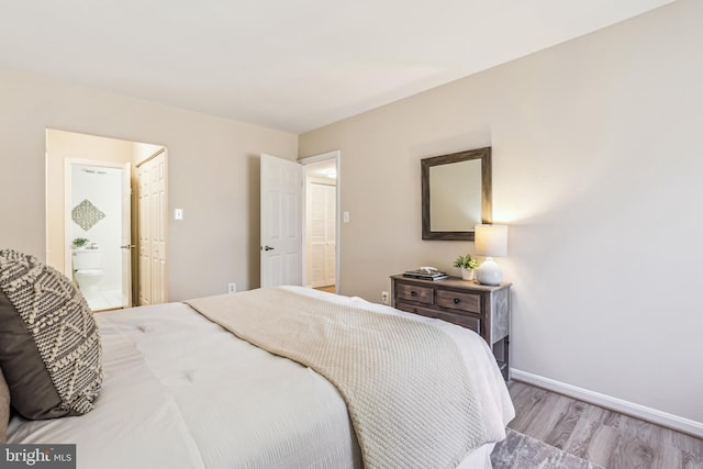 bedroom with ensuite bath and light hardwood / wood-style flooring