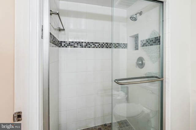 bathroom with toilet and a shower with shower door