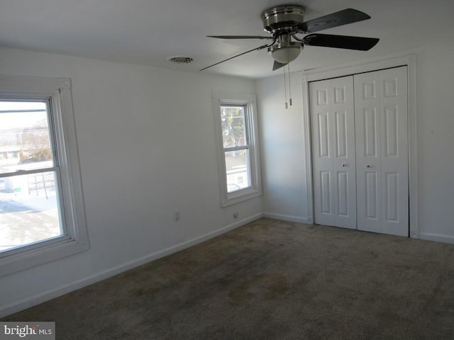 unfurnished bedroom featuring a closet, ceiling fan, and dark colored carpet