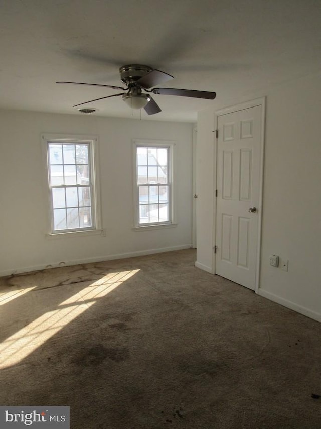 unfurnished room with plenty of natural light, carpet flooring, and ceiling fan