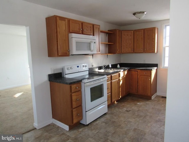 kitchen with light carpet, sink, and white appliances