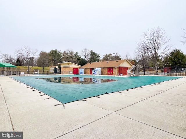 view of swimming pool with a patio and a water slide